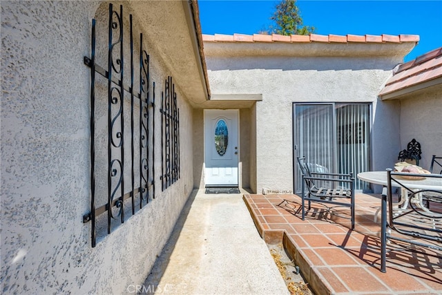 view of exterior entry featuring a patio