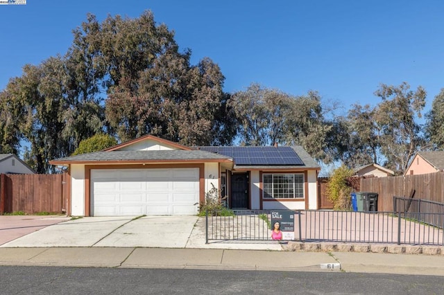 ranch-style home featuring a garage and solar panels