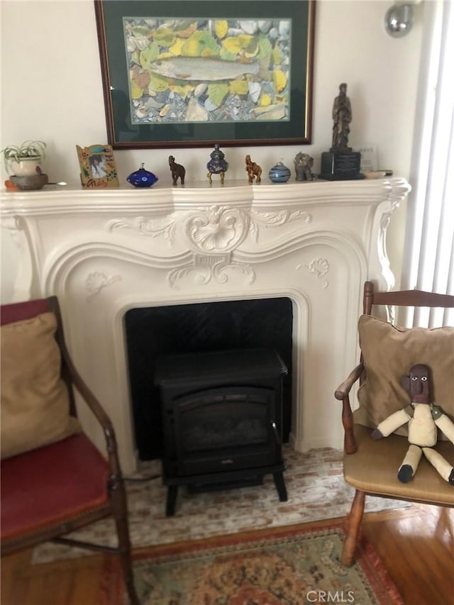 living area featuring hardwood / wood-style flooring and a wood stove