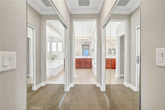 hallway featuring light tile patterned floors, crown molding, and sink