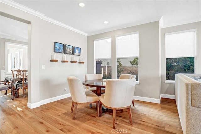 dining area featuring crown molding, hardwood / wood-style flooring, and plenty of natural light