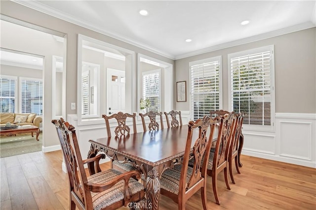 dining space featuring ornamental molding and light hardwood / wood-style flooring