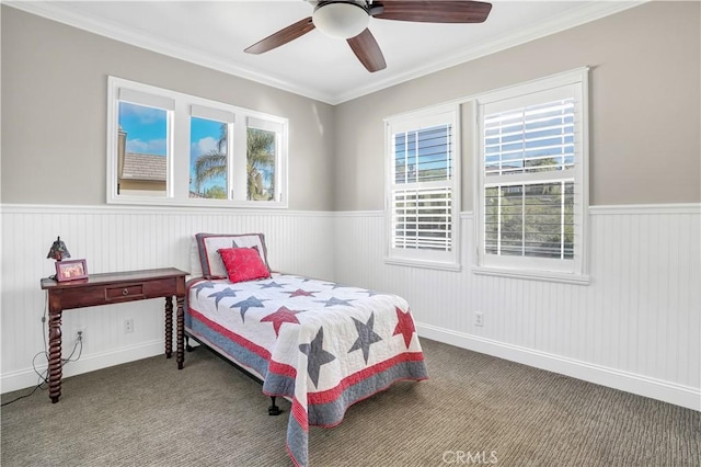 carpeted bedroom featuring crown molding and ceiling fan