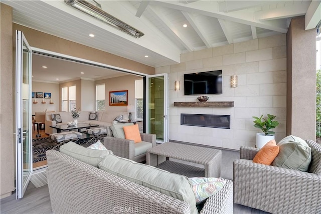 living room with a fireplace, beam ceiling, and light hardwood / wood-style floors