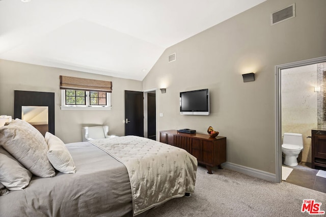 carpeted bedroom with ensuite bathroom and vaulted ceiling