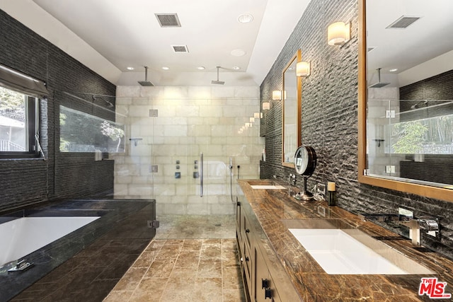 bathroom with shower with separate bathtub, tile walls, and vanity