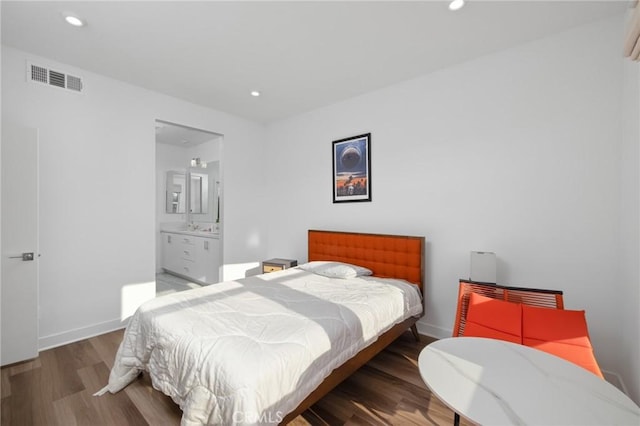 bedroom with sink, ensuite bath, and dark hardwood / wood-style floors