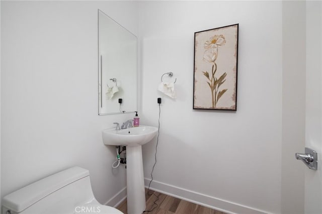 bathroom featuring wood-type flooring and toilet