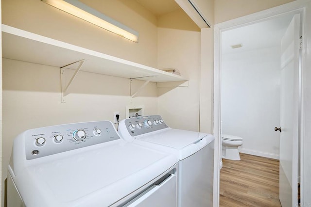 laundry area featuring laundry area, light wood-type flooring, and washing machine and dryer