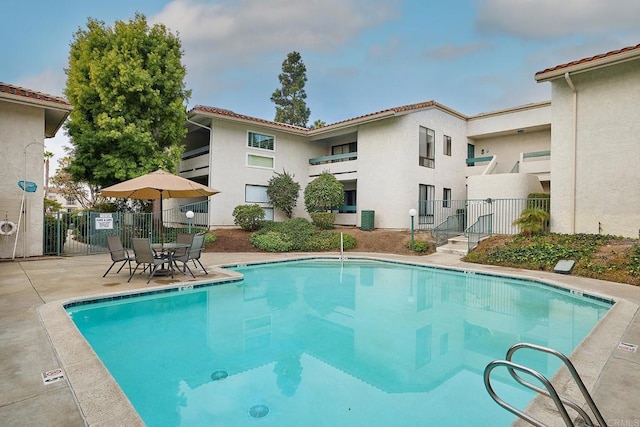 pool with fence and a patio