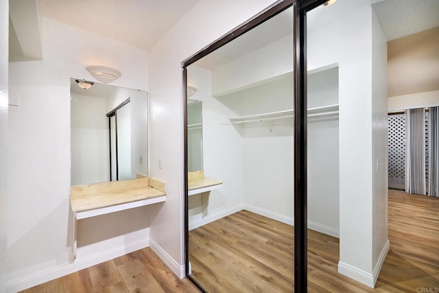 bathroom with wood finished floors and baseboards