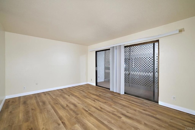 empty room featuring baseboards and wood finished floors