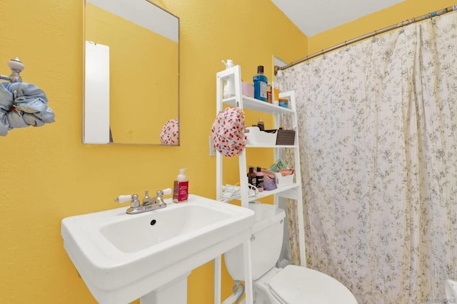 bathroom with toilet, a shower with curtain, and sink