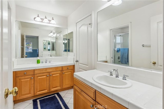 bathroom featuring vanity, a shower with door, and tile patterned floors