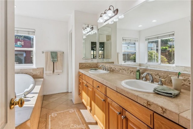 bathroom with a tub to relax in, vanity, and tile patterned flooring