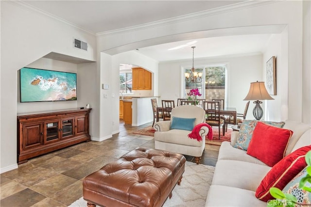 living room with crown molding and a notable chandelier