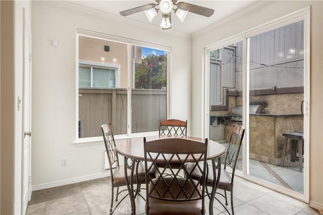 tiled dining room with ceiling fan and ornamental molding