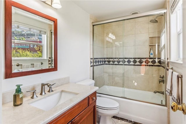 full bathroom featuring toilet, enclosed tub / shower combo, and vanity