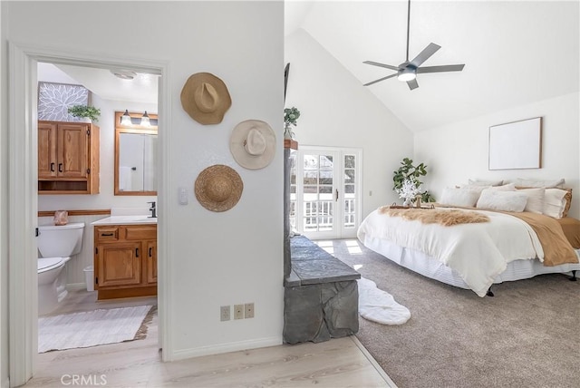 bedroom with ensuite bathroom, ceiling fan, access to exterior, light wood-type flooring, and high vaulted ceiling