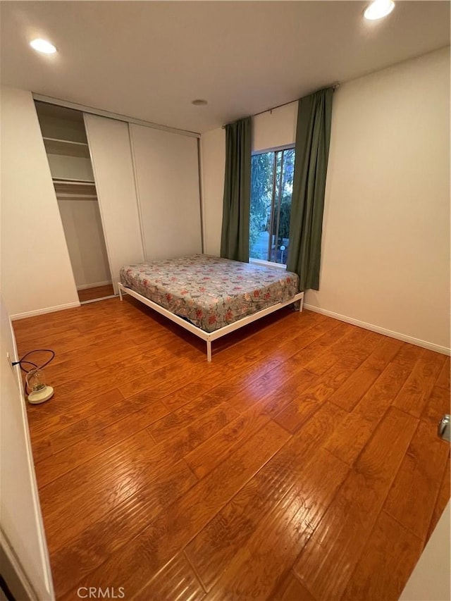 unfurnished bedroom with hardwood / wood-style flooring and a closet