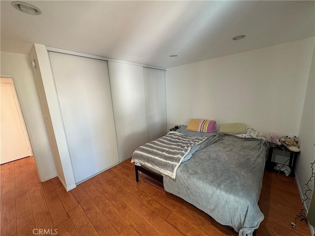 bedroom with hardwood / wood-style floors and a closet