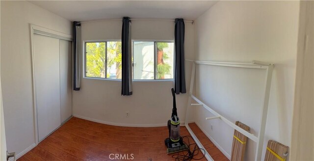 unfurnished bedroom with wood-type flooring and a closet