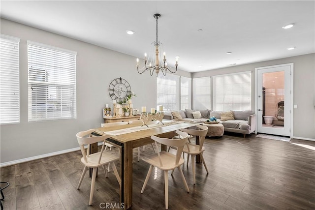 dining area with dark hardwood / wood-style flooring and an inviting chandelier