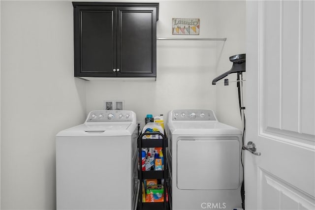 washroom with washer and clothes dryer and cabinets