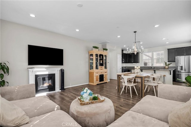 living room with dark wood-type flooring, sink, and an inviting chandelier