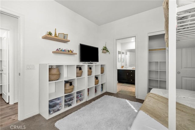 bedroom featuring ensuite bath and carpet flooring