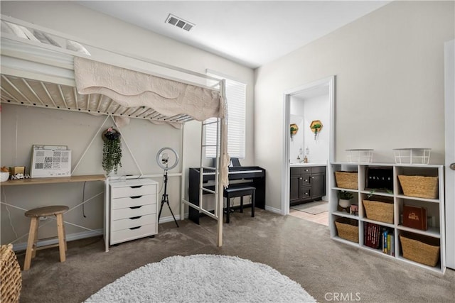 bedroom featuring ensuite bathroom and dark carpet