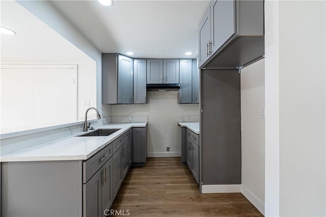 kitchen with dark wood-type flooring, sink, and gray cabinets