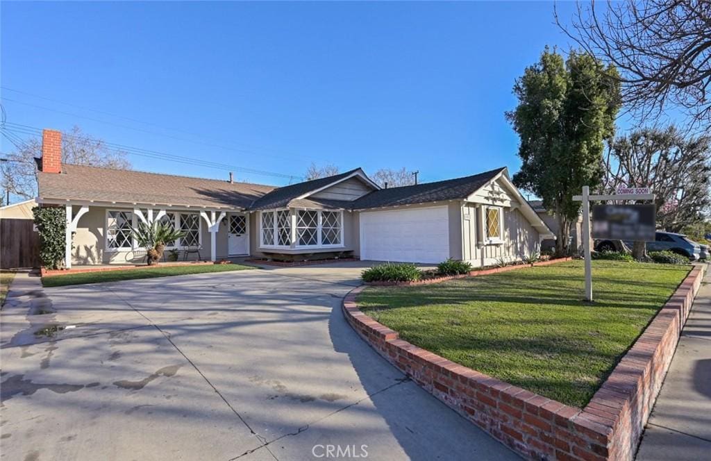 single story home featuring a garage and a front lawn