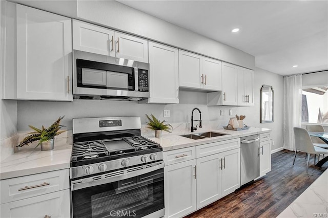 kitchen featuring light stone countertops, white cabinetry, appliances with stainless steel finishes, and sink