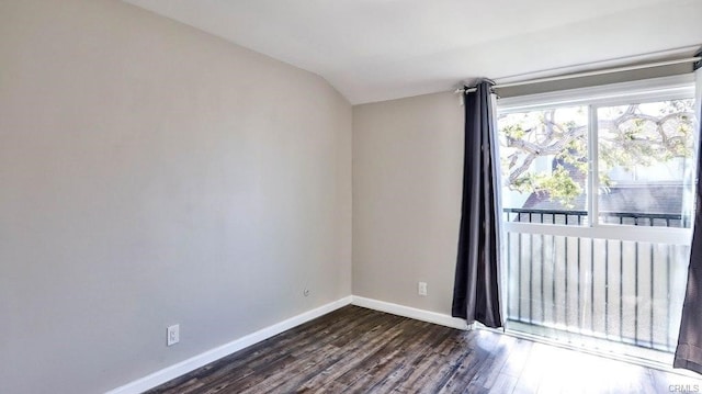 empty room featuring lofted ceiling and dark wood-type flooring