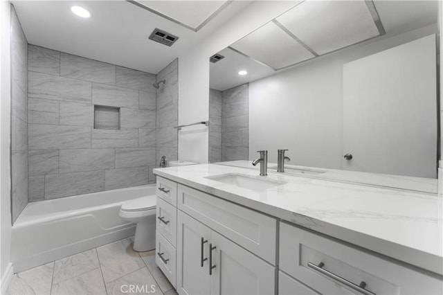 full bathroom featuring toilet, tiled shower / bath, and vanity