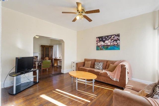 living room with dark wood-type flooring and ceiling fan