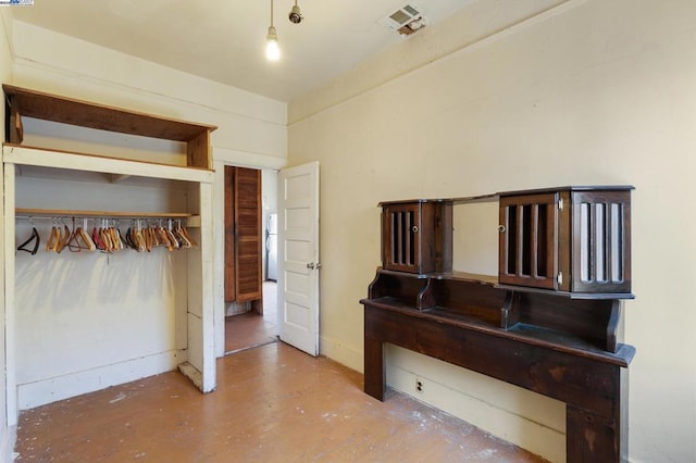 unfurnished bedroom with concrete flooring and a closet