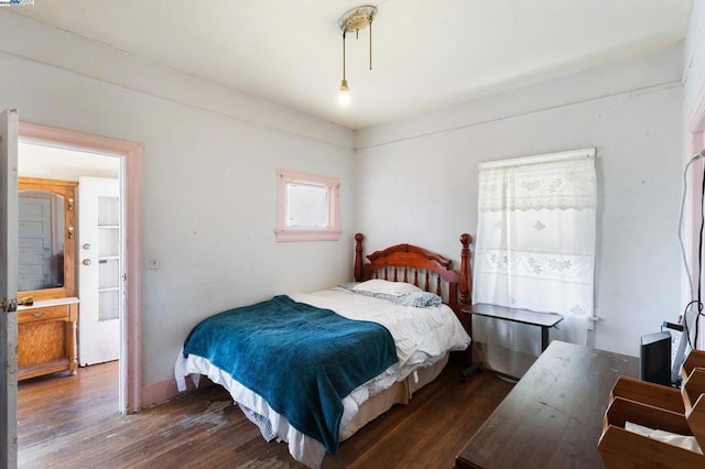 bedroom with dark hardwood / wood-style flooring