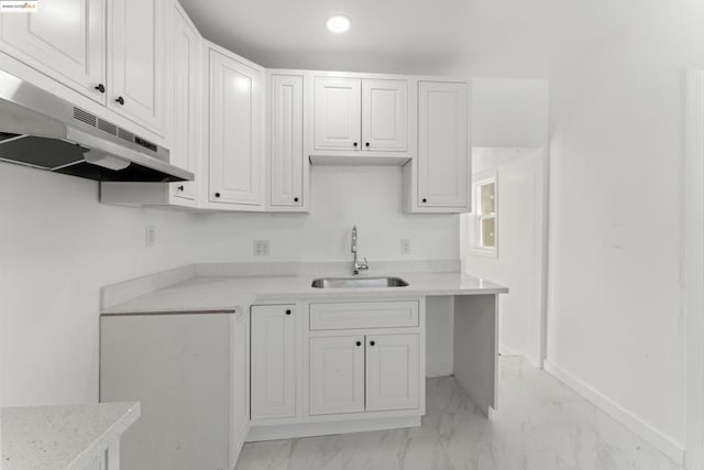 kitchen featuring white cabinetry and sink