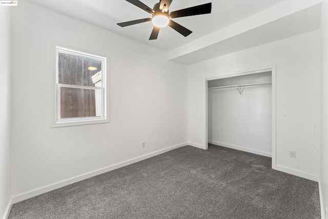 unfurnished bedroom with ceiling fan, dark carpet, and a closet