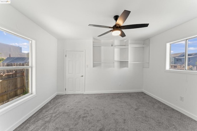 carpeted spare room featuring ceiling fan