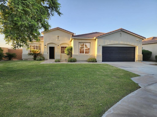 mediterranean / spanish-style home featuring a garage and a front lawn