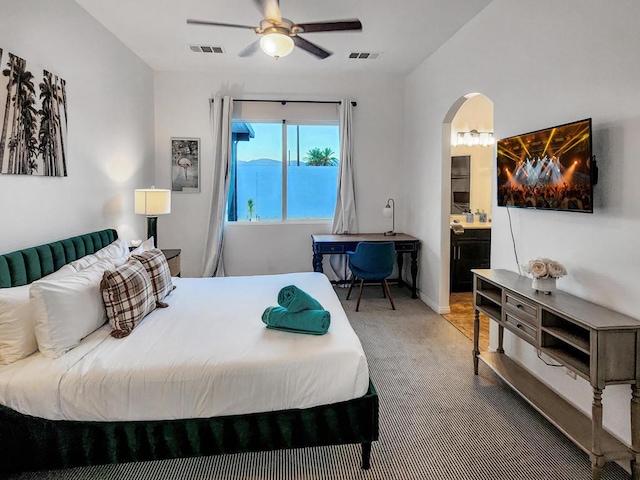 carpeted bedroom with ceiling fan and ensuite bath