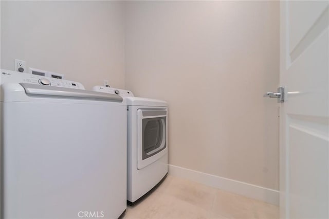 laundry room with light tile patterned floors and washer and clothes dryer