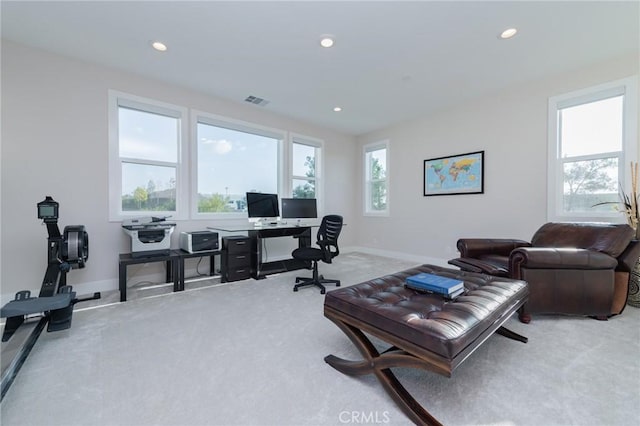 office area with a wealth of natural light and light carpet