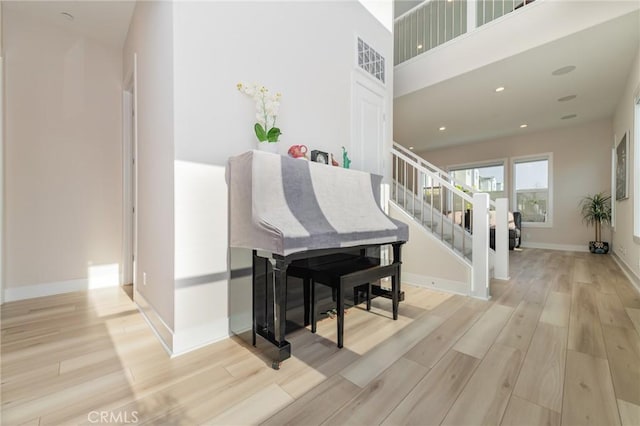 stairs with a towering ceiling and hardwood / wood-style floors