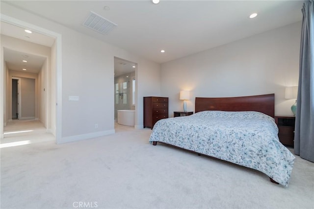 bedroom with ensuite bathroom and carpet flooring