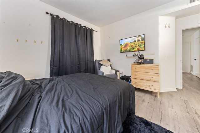 bedroom featuring visible vents and wood finished floors