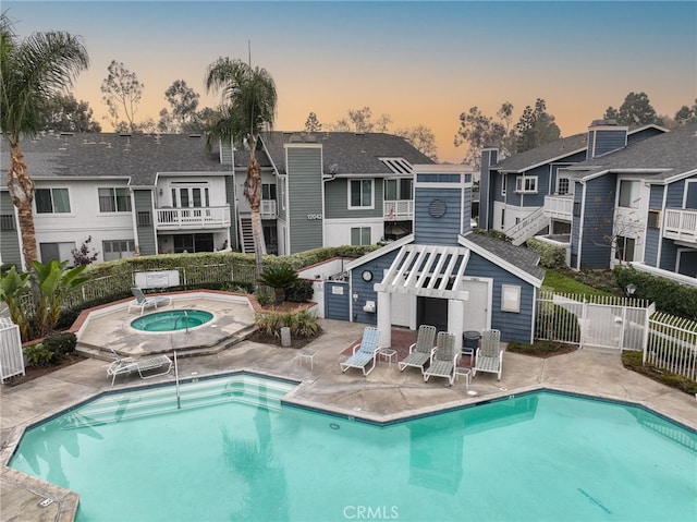 rear view of house featuring a patio area, a residential view, fence, and a community hot tub